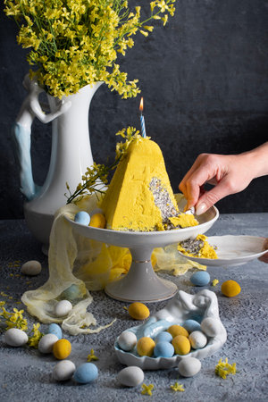 Traditional Easter Orthodox curd cake with yellow flowers on a grey table