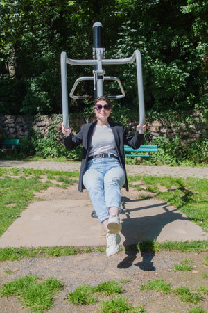 Brunette woman is engaged in a street sports simulator in the park, Sports