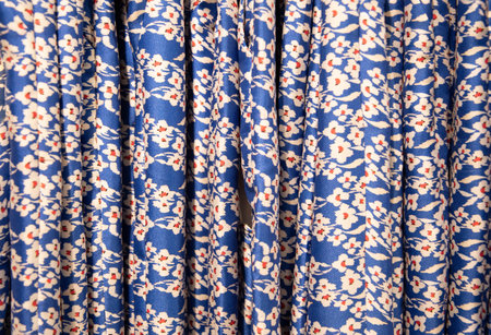 blue with red flowers summer blouses on a hanger in the store, bright clothesの写真素材