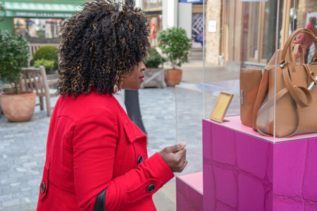 curvy african american woman walks on standing on the shopping street and looksの写真素材