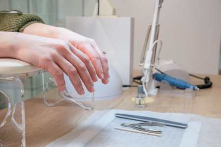 a skilled manicurist does a manicure to a client in a beauty salonの写真素材
