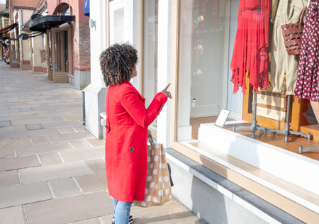 curvy african american woman with shopping bags standing on the streetの写真素材