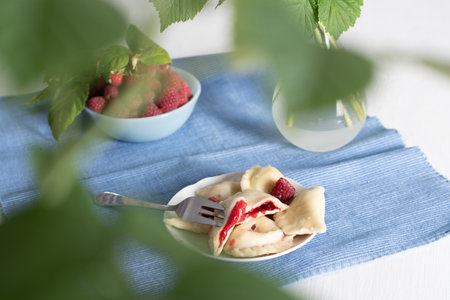 Slavic dish vareniki with fresh raspberries, Still life on a blue backgroundの写真素材