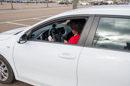 African Businesswoman in red coat using disinfectant wet tissue wipe on steering wheel, prevent epidemic coronavirus in her car, Cleaning, Antisepticの写真素材