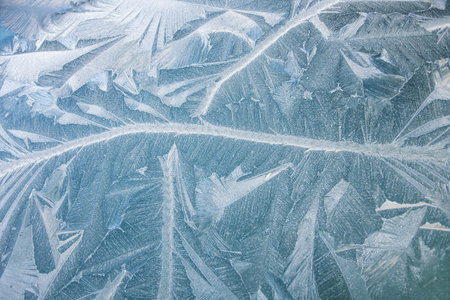 nature draws frost patterns on the glass with the freezing air temperature,abstract winter pattern