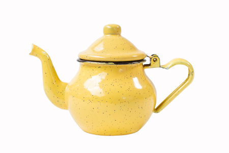 vintage enamel yellow teapot with spotted pattern with curved spout and handle resembling heart shape isolated on transparent backgroundの写真素材