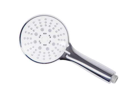 Chrome shower head resting on a white background, highlighting a sleek design with multiple water outlets, offering an invigorating and refreshing shower experienceの写真素材