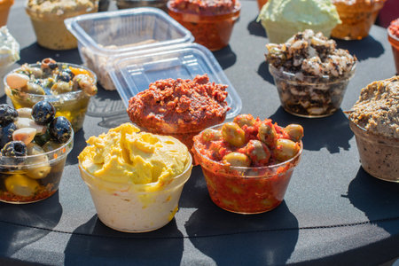 On table are bowls filled with colorful sauces, olives and other Mediterranean delicacies, offering a variety of flavors and textures to choose from.の写真素材