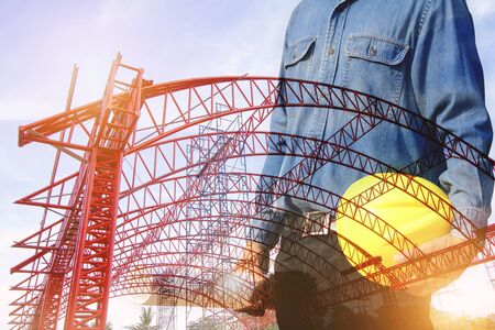 Double image of an engineer with a helmet with a steel roof structure backgroundの写真素材