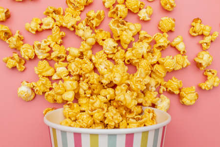 Caramel of pop icons in multicolored cups on pink background
