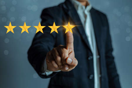 A man in a business suit gives a five stars rating. Rating increase concept, classification.