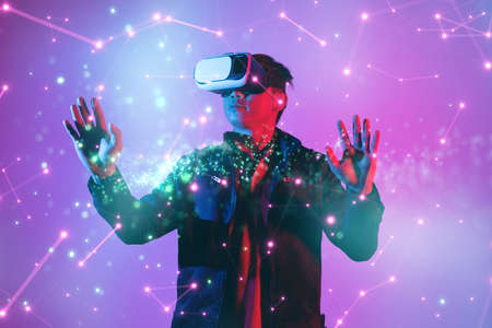 Metaverse digital cyber world technology, man with virtual reality VR goggle playing AR augmented reality game and entertainmentの写真素材