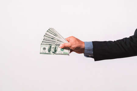 Businessman in suit holding several 100 dollar bills. Finance concept.