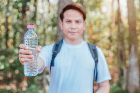 male tourist carrying water bottleの写真素材