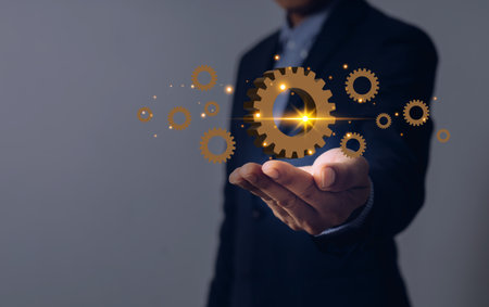 business man with hands and gears on palm industrial conceptの写真素材