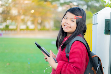 Asian girl watching a table on the school lawnの写真素材