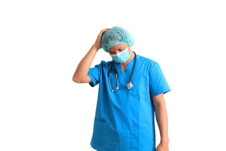 Asian male doctor wearing blue scrubs and mask on white background.の写真素材