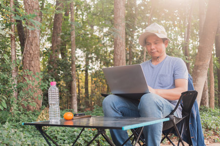 Asian man sitting in the garden under the treeの写真素材
