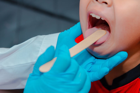 The doctor uses a tongue depressor to examine the child's tongue.の写真素材