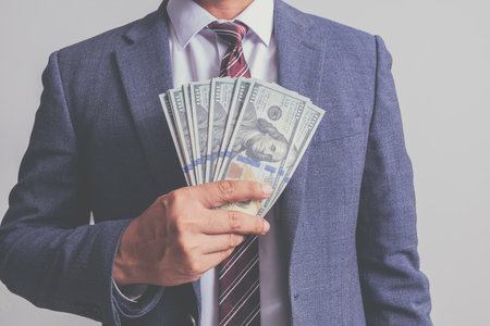 closeup businessman in suit holding one hundred 100 dollar bill. money conceptの写真素材