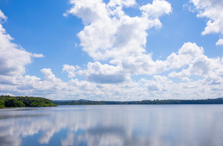 Landscape view of a lake with blue sky and white clouds.の写真素材