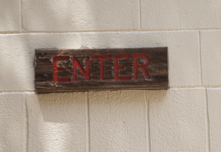 Close up of wooden enter sign on brick backgroundの写真素材