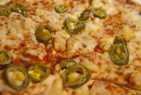 Close up of pineapple and jalapeÃ±o pizza, slicedの写真素材