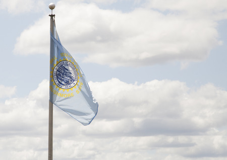 South Dakota state flag waving in blue skyの写真素材
