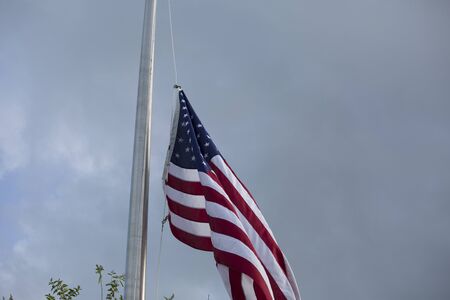 American flag at half mast for mourning and holidaysの写真素材