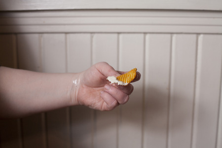 Someone eating a potato chip and onion dipの写真素材
