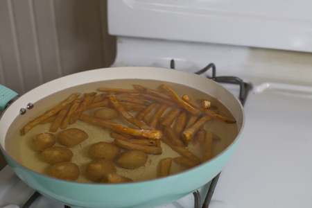 French fries and hush puppies immersed in cooking grease