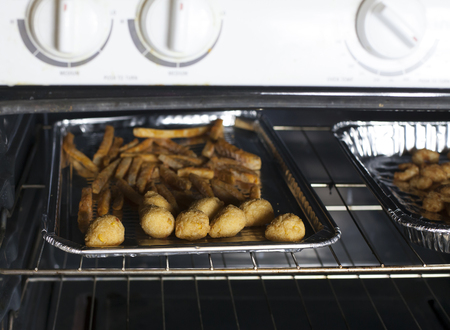 Hush puppies and French fries baking in the ovenの写真素材