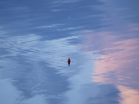 Fishing bobber floating on the top of lake water