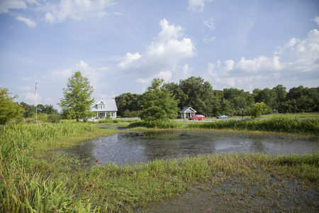 MONROE, LOUISIANA - June 20, 2014: Small pond with cars in the backgroundのeditorial素材