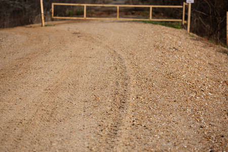 Tire track leading down a rocky, gravel road
