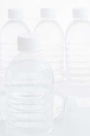 Plastic drink water bottles sealed with white bottle caps.の写真素材