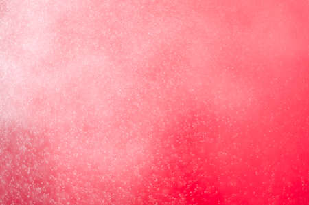 Water spray splashing on red color tone background.の写真素材