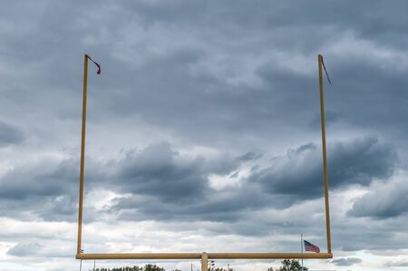 Outdoor football field goal with gloomy rainy sky background.の写真素材