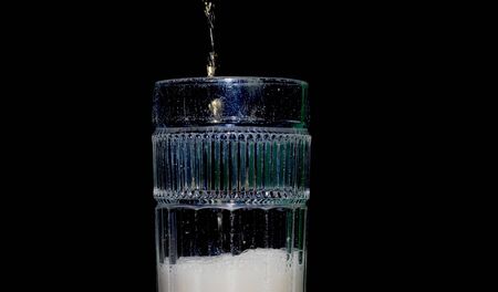 Beer being poured in a glass cupの写真素材