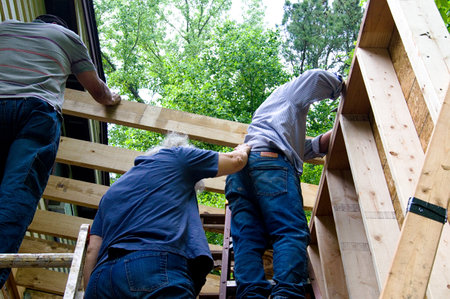 People doing construction work, one holding the other for support