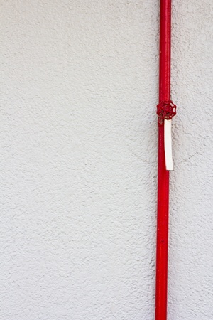 Red pipe valve on the wallの写真素材