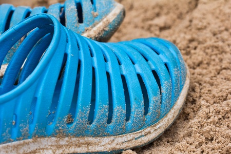 Blue flip flops laying on the sandy の写真素材