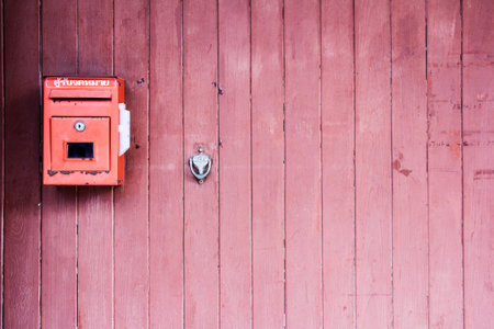Red mailbox on the red wooden doorの写真素材