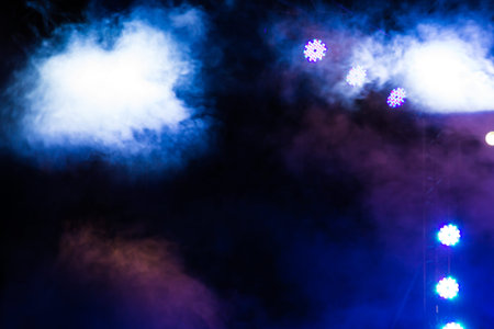 spotlights that illuminate the stage at a concert with smog