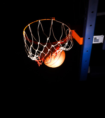 Basketball hoop on black background with light effectの写真素材