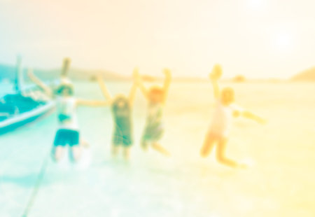 Blur bacground happy young people jumping on the beach with color filtersの写真素材
