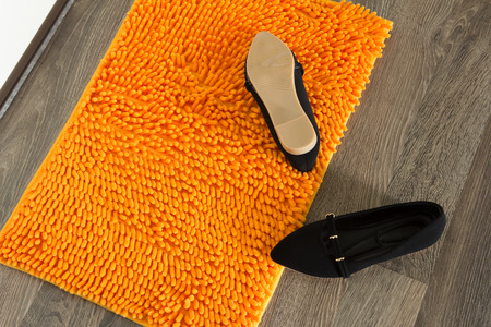 Door mat with black shoes on front doorの写真素材