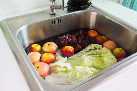 wash fersh fruit and vegetable in sinkの写真素材