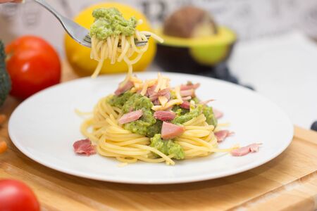 Spaghetti with fish and pesto sauce on white plate. Traditional italian cuisine.の写真素材