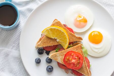 Breakfast - Sandwich with ham and tomatoes on plateの写真素材